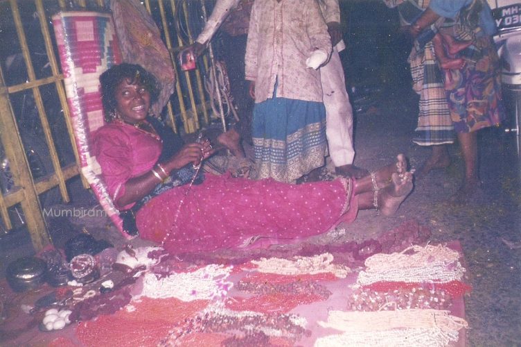 Shani and her shop, Mumbiram Shani looks happy and relaxed with her legs stretched out on the side of her well-stocked shop